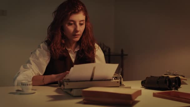 Ung flicka skriver på skrivmaskin vid ett bord — Stockvideo
