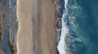 Aerial overhead of stormy waves of ocean and beach