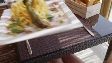 Masada servis edilen balık tabanlı bir tabakta yemek.