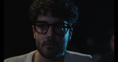 Çocuk yakın sinemada oturmuş film izliyor.