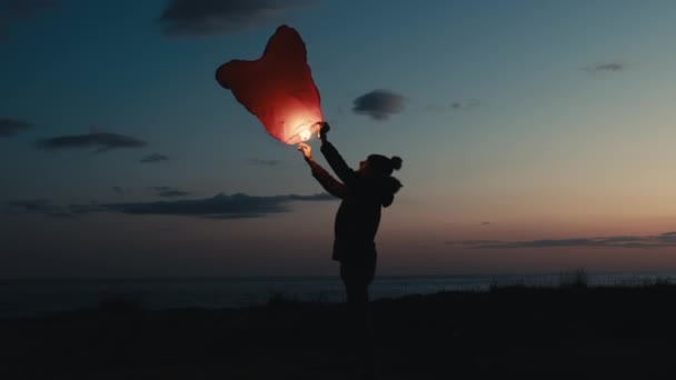 Silhouet van een jonge jongen die met een Chinese lantaarn vliegt — Stockvideo