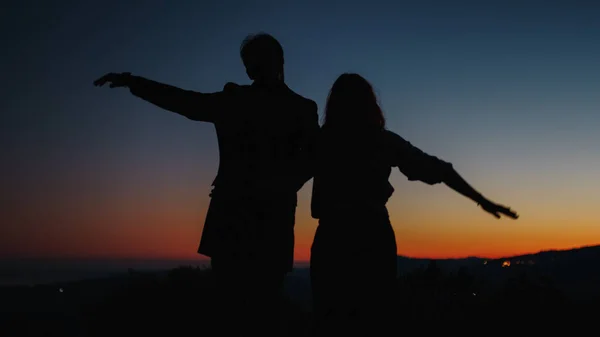 Silhouette de garçon et de fille font l'avion avec leurs bras — Photo