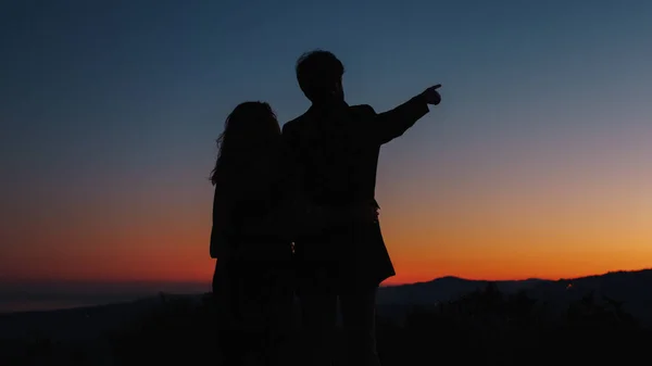 La silhouette del ragazzo e della ragazza indica le stelle nel cielo — Foto Stock