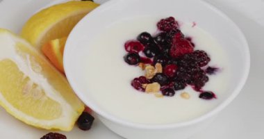 Müsli yoğurt ve yabanmersini dolu bir kaba düşer.