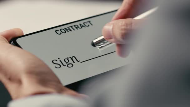 Χέρι υπογράφει με σταυρό ένα έγγραφο σύμβασης σε απευθείας σύνδεση με το τηλέφωνο — Αρχείο Βίντεο