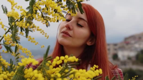 Chica joven celebra el día de la mujer con flores de mimosa amarillas en la mano — Vídeos de Stock