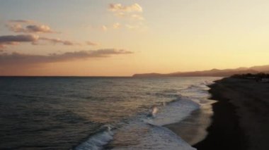 Sahil kenarında gün batımında turuncu sakin okyanus.