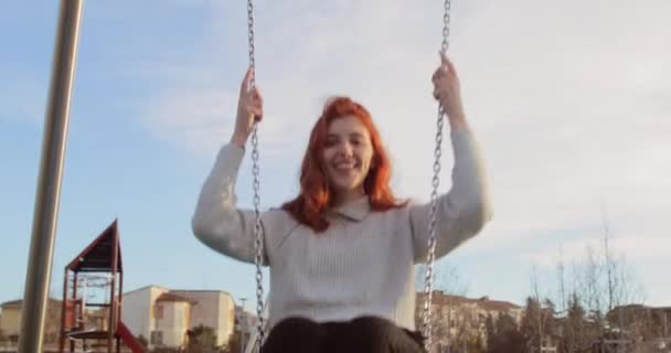 Νεαρό όμορφο κορίτσι έχει τη διασκέδαση σε ένα πάρκο με την ταλάντευση στη φύση — Αρχείο Βίντεο