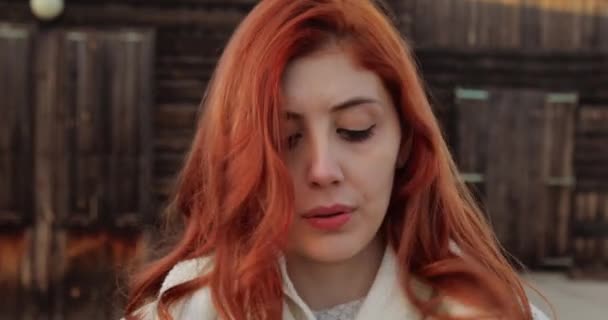 Молода дівчина з рудим волоссям знімає шарф на початок спеки — стокове відео