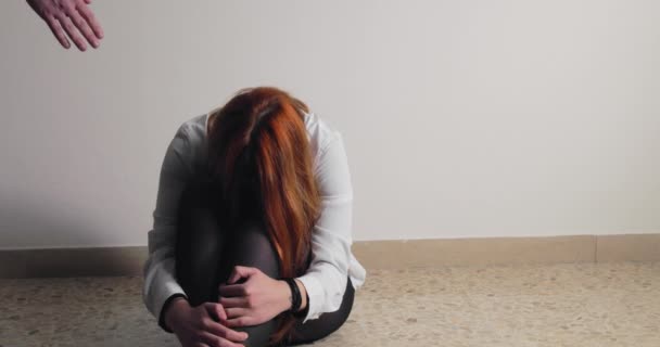 Дівчині допомагає рука після насильства на підлозі кімнати — стокове відео
