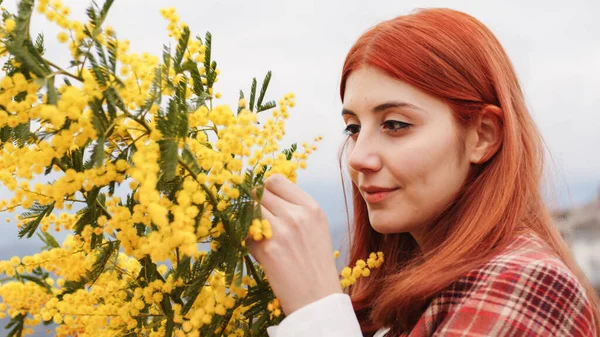 Chica joven celebra el día de la mujer con flores de mimosa amarillas en la mano — Foto de Stock