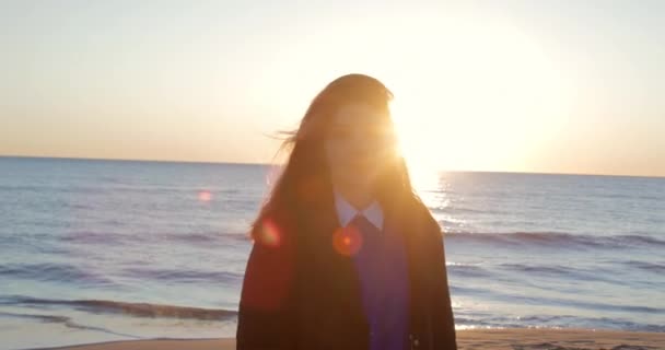 Silhuett av en vacker flicka vänder ryggen och går till havet vid solnedgången — Stockvideo