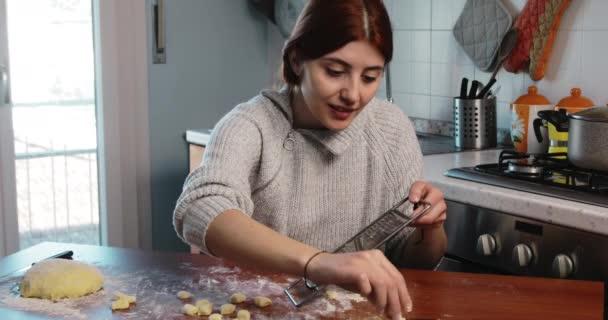 Jong meisje is stempelen zelfgemaakte kleine gnocchi op de keukentafel — Stockvideo