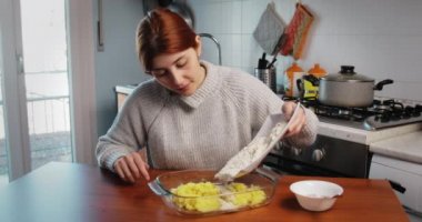 Genç kız mutfak odasında ev yapımı patates gnocchi yapıyor.