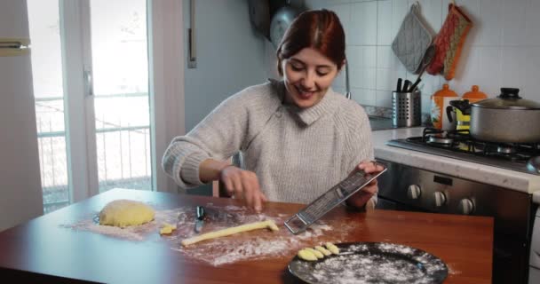 Mutfak masasında ev yapımı gnocchi için şekil kesen genç bir kız. — Stok video