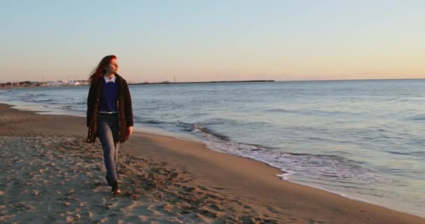 หญิงสาวที่มีสติเดินคนเดียวบนชายฝั่งมหาสมุทรตอนพระอาทิตย์ขึ้น — วีดีโอสต็อก