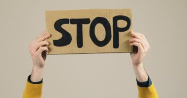 Sarı tişörtlü çocuk elinde savaş ilan panosunu tutuyor.