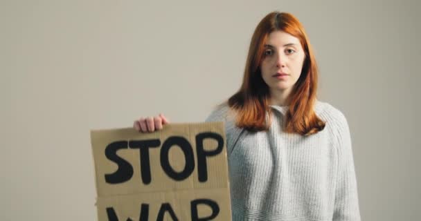 Young girl raises up the billboard that says stop war during the protest — Stock Video