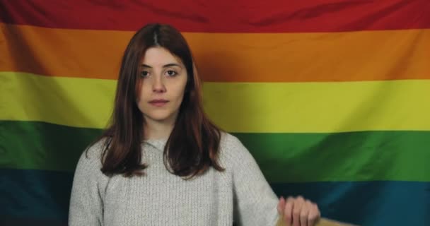 Girl holds up a billboard that says no violence and peace flag background — Stock Video