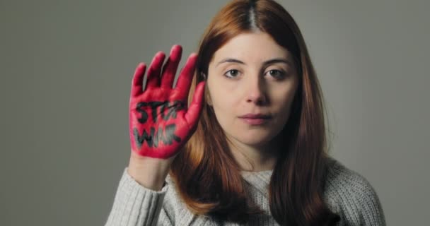 Jeune fille se rebelle contre la guerre et dit stop avec la main rouge écrite — Video