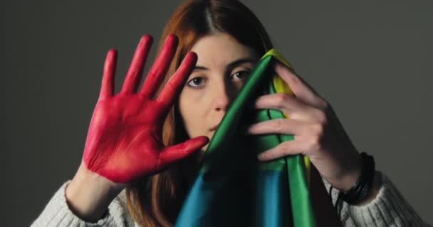 Meisje verbergt zich in angst en steekt haar rode hand op als een teken van stoppen — Stockvideo