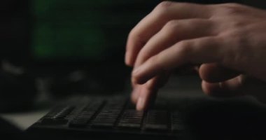Hacker odasındaki klavyeye tuşları yazıyor.
