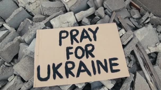 Verlaten reclameborden op het puin van gebouwen die verwoest zijn door bombardementen in Oekraïne — Stockvideo
