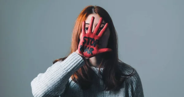 Girl rebels against the system and refuses war by painting her hand red — Stock Photo, Image