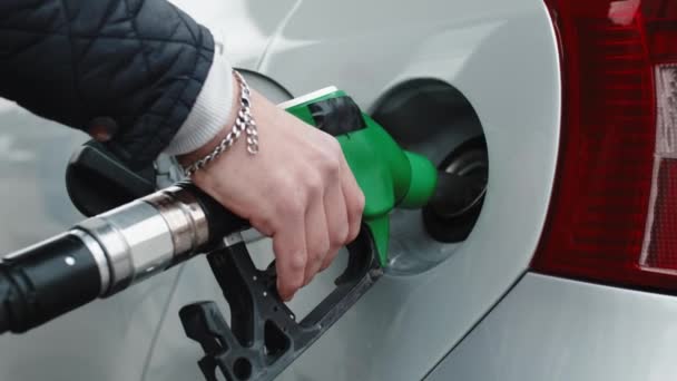 En bensinstationsmans hand sätter bensin i en bil. — Stockvideo