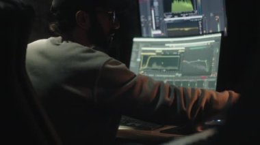 Arkadan oturan ses mühendisi ses müziğini karıştırmak için bilgisayarı kullanıyor