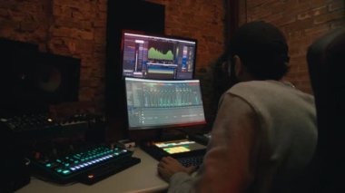 Çocuk DJ yapımcısı bilgisayardaki yazılımla müziği karıştırıyor.