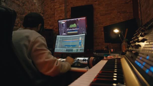 Boy dj productor mezclando una música con un software en el ordenador — Vídeos de Stock