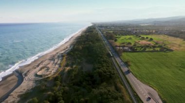 Denize yakın bir demiryolunda giden küçük bir trenin izini sürüyorum.