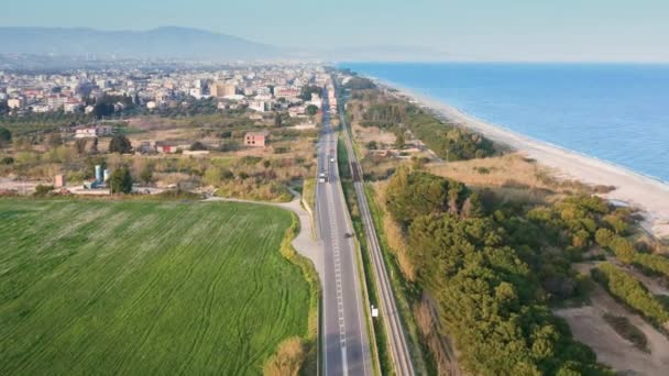 Дорога з невеликим рухом для доступу до маленького села біля моря з пляжем — стокове відео