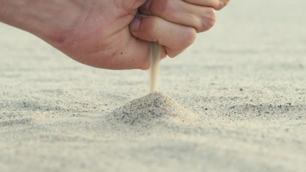 En pojkhand släpper en sandhög från stranden. — Stockvideo
