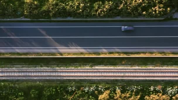 Licht verkeer op een weg die parallel loopt aan een trein — Stockvideo