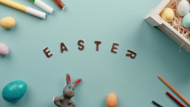 Velikonoční text na modrém pozadí s barevnými vejci — Stock video