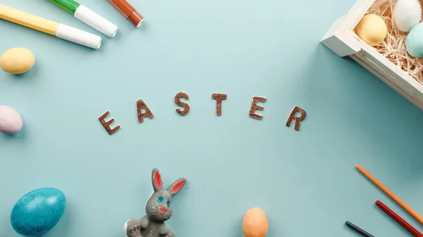 Teks Paskah pada latar belakang biru dengan telur berwarna — Stok Foto