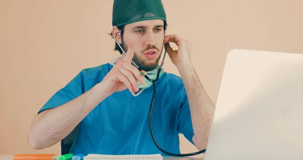 Un médico joven hace un diagnóstico desde el ordenador de forma remota — Foto de Stock