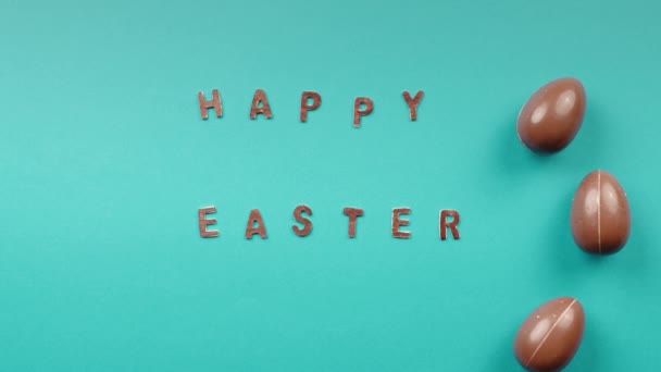 Easter chocolate eggs rolling on a yellow background — Stock Video