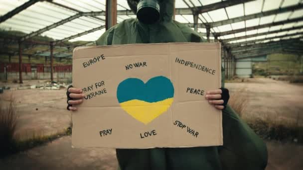 Homme avec masque à gaz et plaque de paix pour la guerre en Ukraine — Video