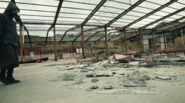 Gaz maskeli adam nükleer bir patlamanın enkazında yürüyor.