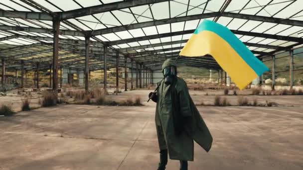 Στρατιώτης με μάσκα αερίου κύματα ουκρανική σημαία σε μια αποθήκη πολέμου — Αρχείο Βίντεο