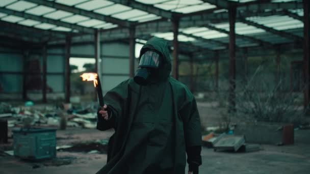 Soldaat man met gasmasker in een verwoest gebouw door oorlog met fakkel — Stockvideo