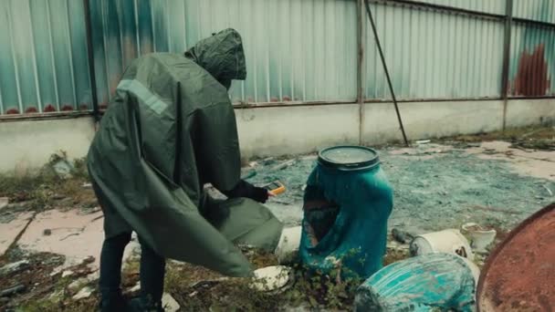 Людина з газовою маскою перевіряє рівень випромінювання за допомогою лічильника гейзерів у сараї — стокове відео