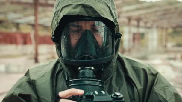 Military man with gas mask and camera photographs the destruction of the bomb — Stock Video