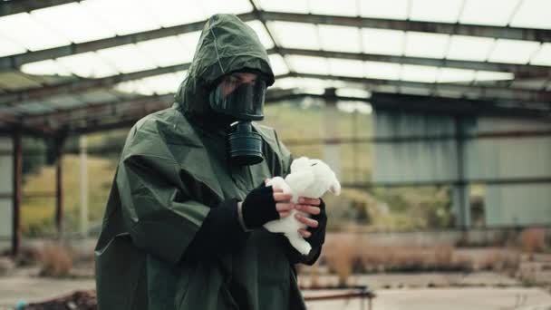 Mannen med gasmask hittar ett gosedjur på ett krigshärjat sjukhus. — Stockvideo