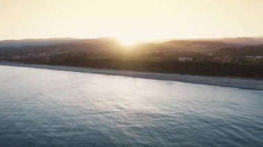 Günbatımında Calabria 'da sakin deniz olan Locri plajı.