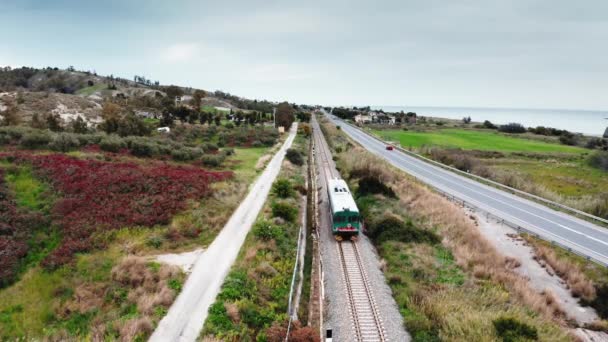 Trein passeert in de spoorlijn naar de achtergrond in Calabrië land — Stockvideo