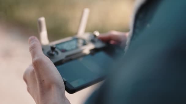 Рука оператора дрона во время пилотирования дистанционного контроллера квадрокоптера. — стоковое видео